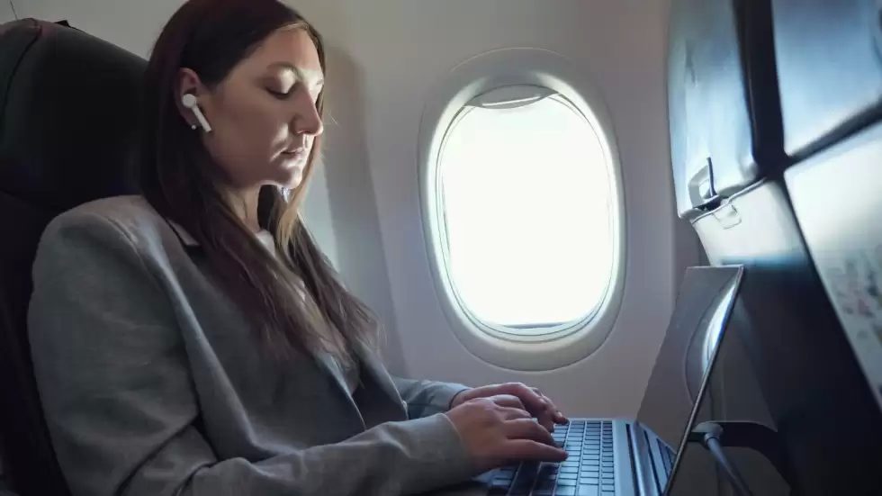 brunette-woman-suit-wireless-earphone-ear-is-typing-text-laptop-while-sitting