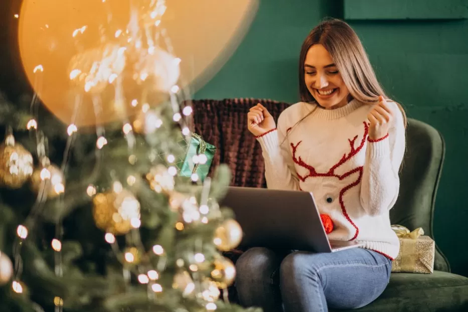 woman-sitting-by-christmas-tree-shopping-online-sales