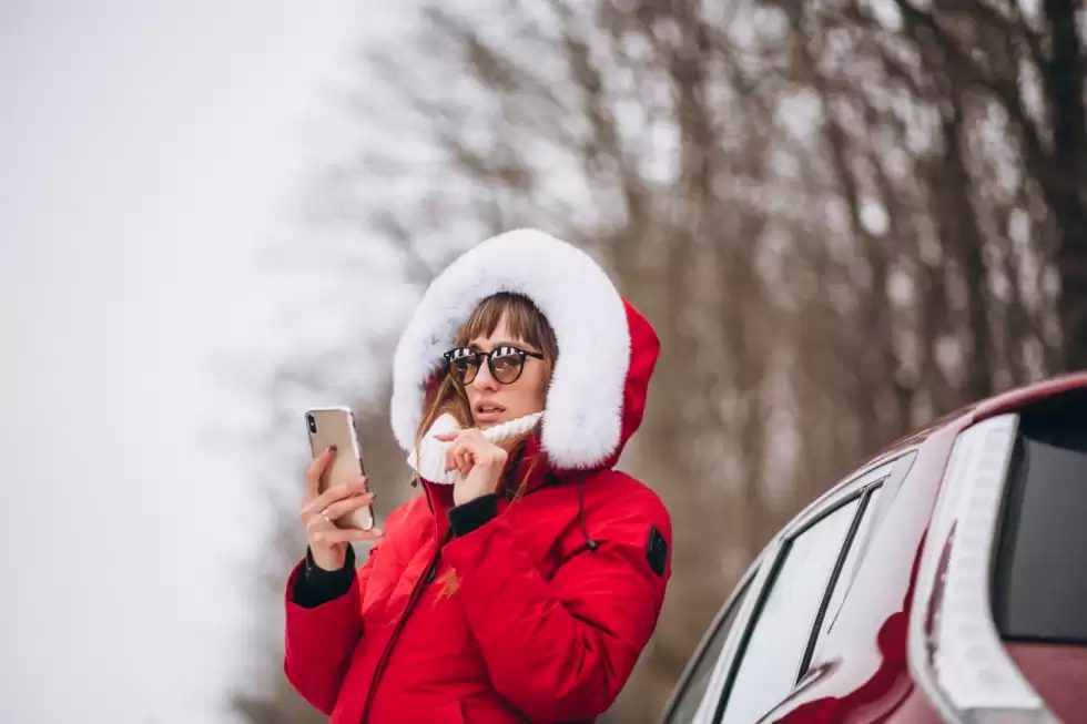woman-happy-talking-phone-outside-by-car-winter